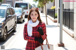 A woman wearing a red and black plaid shirt and a white scarf.