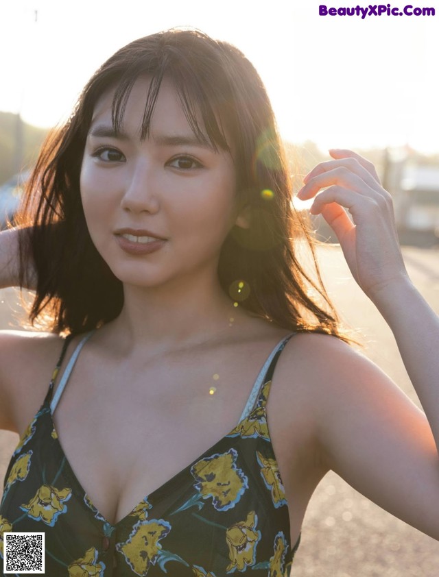 A woman in a black and yellow dress posing for a magazine.