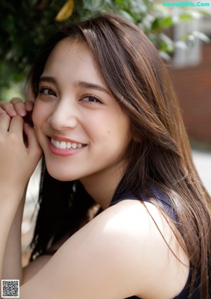 A woman in a black top and yellow skirt posing for a picture.