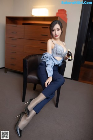 A woman in a business suit sitting on a couch.