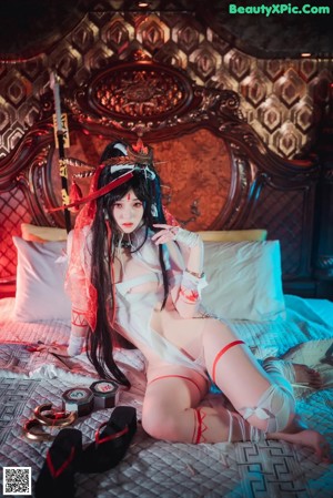 A woman sitting on a bed holding a sword.