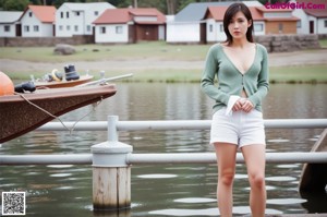 A woman in a green sweater and white skirt posing for a picture.