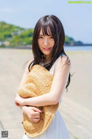 A woman in a pink bikini holding a white towel.