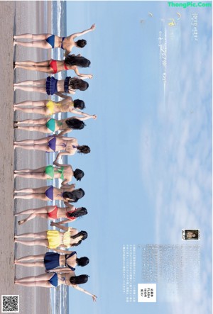 A group of women in bikinis posing for a picture on the beach.