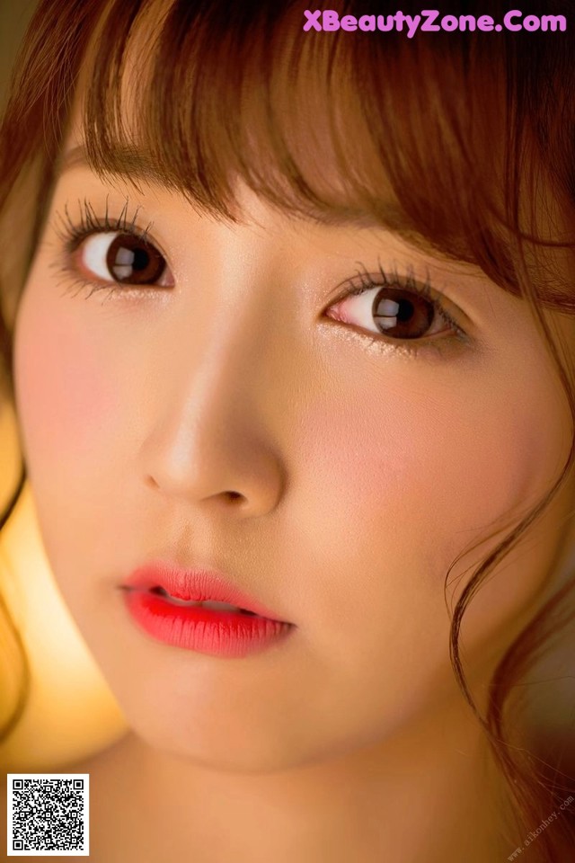 A close up of a woman's face with long brown hair.