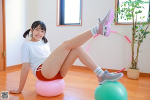 A woman in a pink bikini standing next to a pink ball.