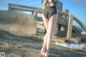 A woman in a blue and white one piece swimsuit standing in the water.