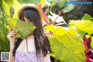 a japanese woman in a white bikini sitting on the grass