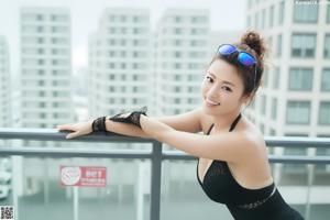 A woman in a black bathing suit posing for a picture.