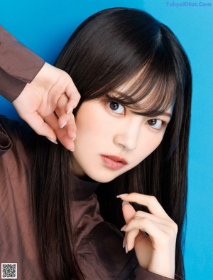 A woman with long black hair and bangs posing for a picture.