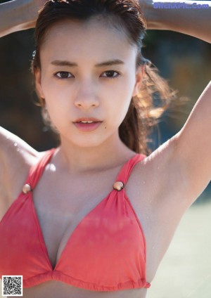 A young woman laying on top of a black blanket.