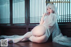 A woman in lingerie sitting on the floor in a room.