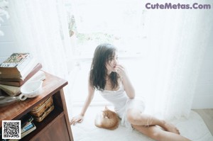 A woman in a black and white photo is putting on her underwear.