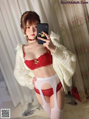 A woman in a red lingerie holding a red gift box.