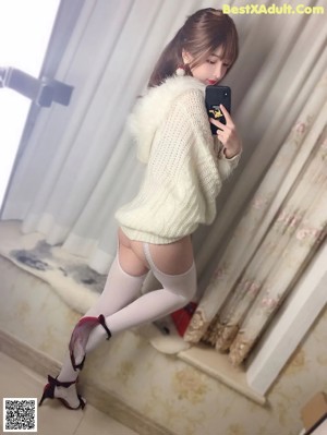A woman in a red and white lingerie sitting on a bed.