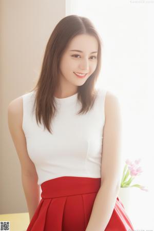 A woman in a white shirt and yellow panties sitting on a couch.