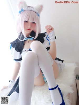 A woman in a bunny costume is sitting on a bed.