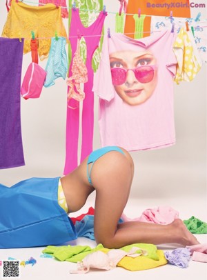 A woman laying on top of a pile of clothes.