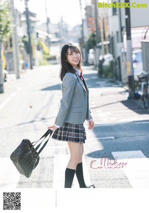 A woman in a school uniform is smiling for the camera.