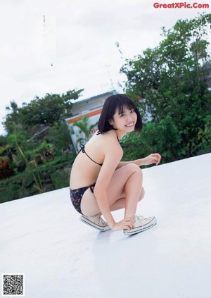 A woman laying on top of a bed next to a palm tree.