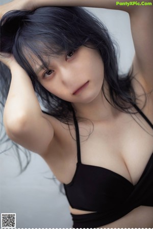 A woman with long black hair is posing for a magazine.