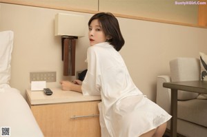 a woman in a white shirt holding a glass of water