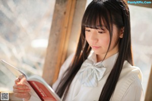 A young woman in a school uniform posing for a picture.